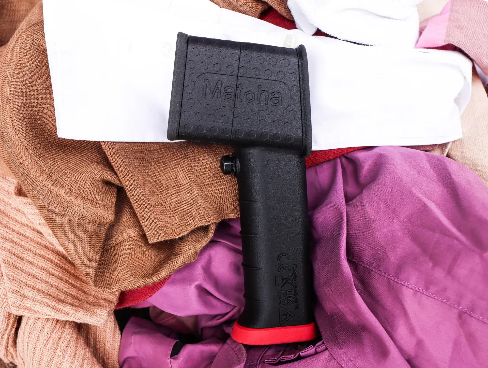 FabriTell Handheld scanning a pile of sorted garments